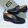 A pair of premium black leather loafers with sleek buckle detail, displayed on a white box with a grey shoe box in the background.
