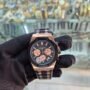 A luxurious watch with a black and rose gold design, held by a gloved hand, showcasing its intricate details and precision engineering.
