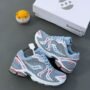 A pair of Saucony sneakers in light blue, white, and red, accompanied by a white shoe box and a small toy, showcasing the shoe's premium design.