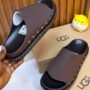 Luxurious brown slides with bronze studs on a wooden background, exuding high-end quality and sophistication.