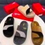 A luxurious display of Puma slides in various colors, perfectly arranged on a pristine white table with matching red boxes, exuding high-end quality and sophistication.