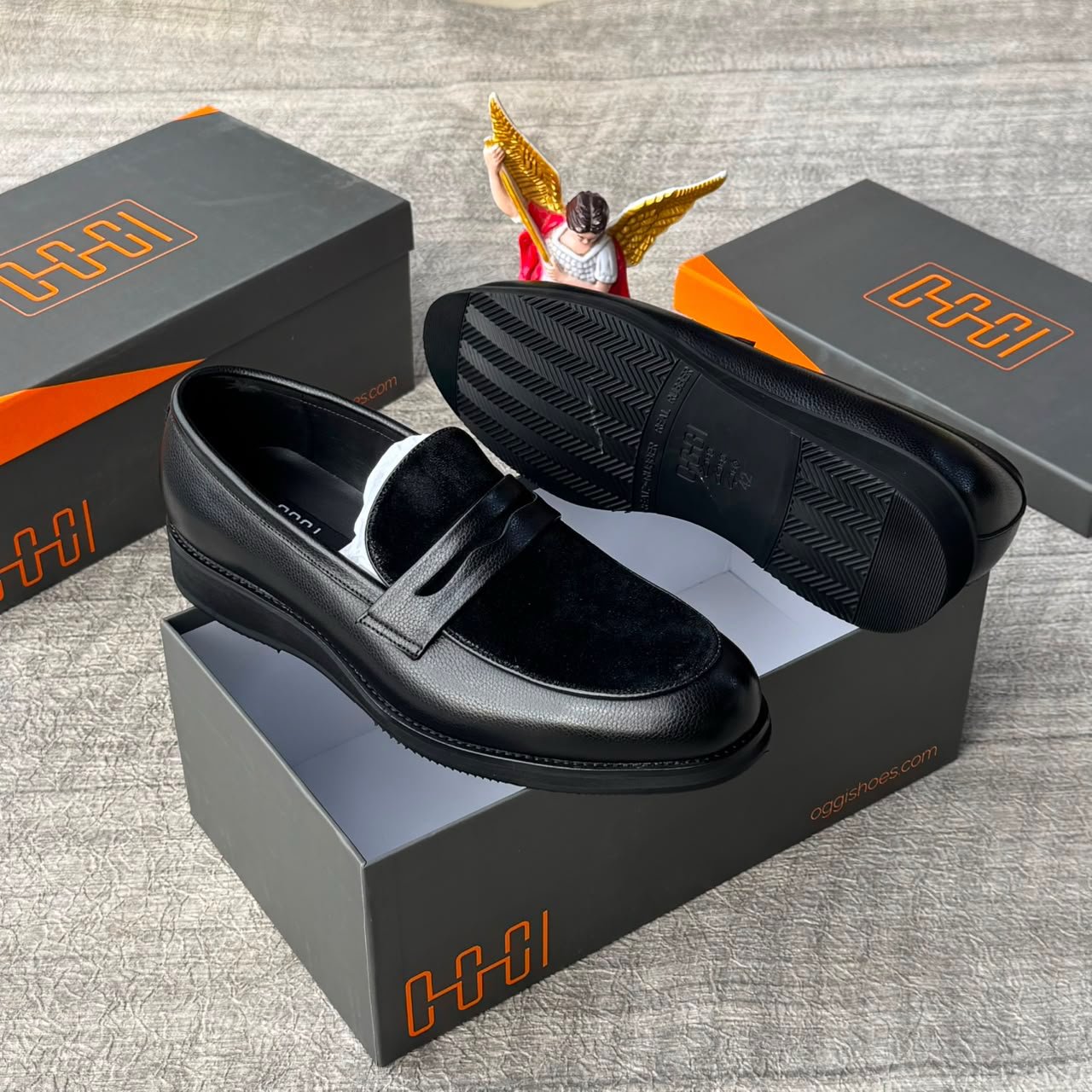 A pair of luxurious black loafers displayed on a shoe box, exuding sophistication and elegance. The sleek design and premium materials are showcased in this high-quality image.